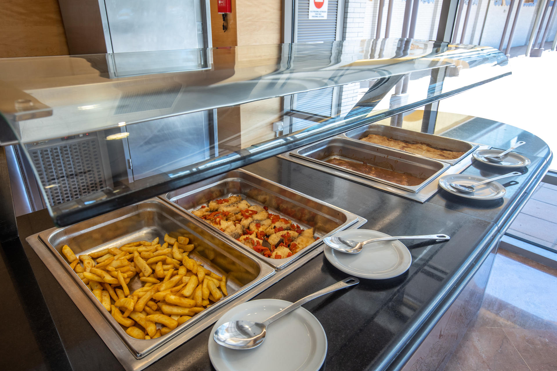 French fries, fried fish with peppers, meat in sauce, empanada