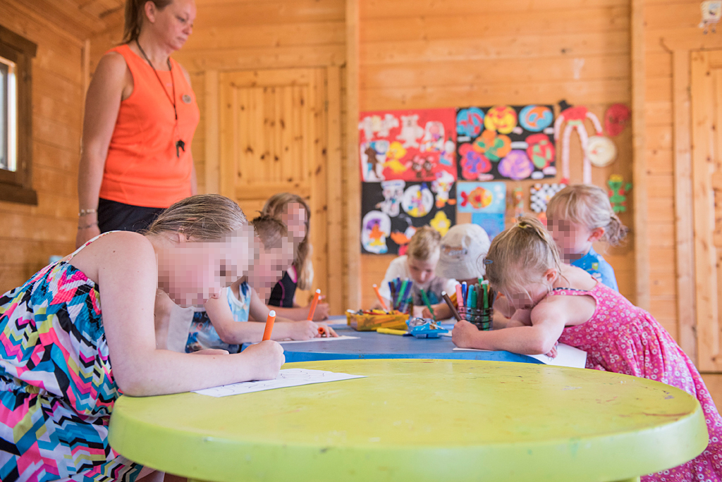 Children coloring in hotel activities.