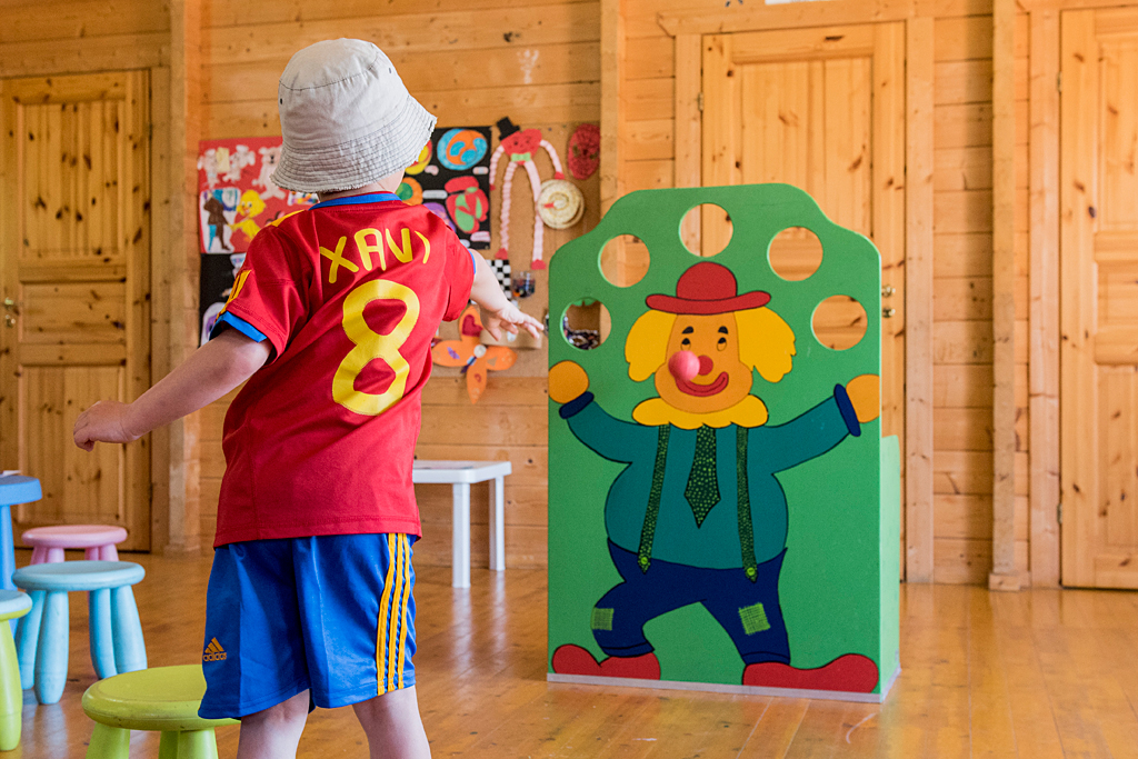 Child playing darts at hotel activities.