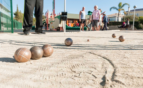 Varios hombres jugando una partida de petanca.